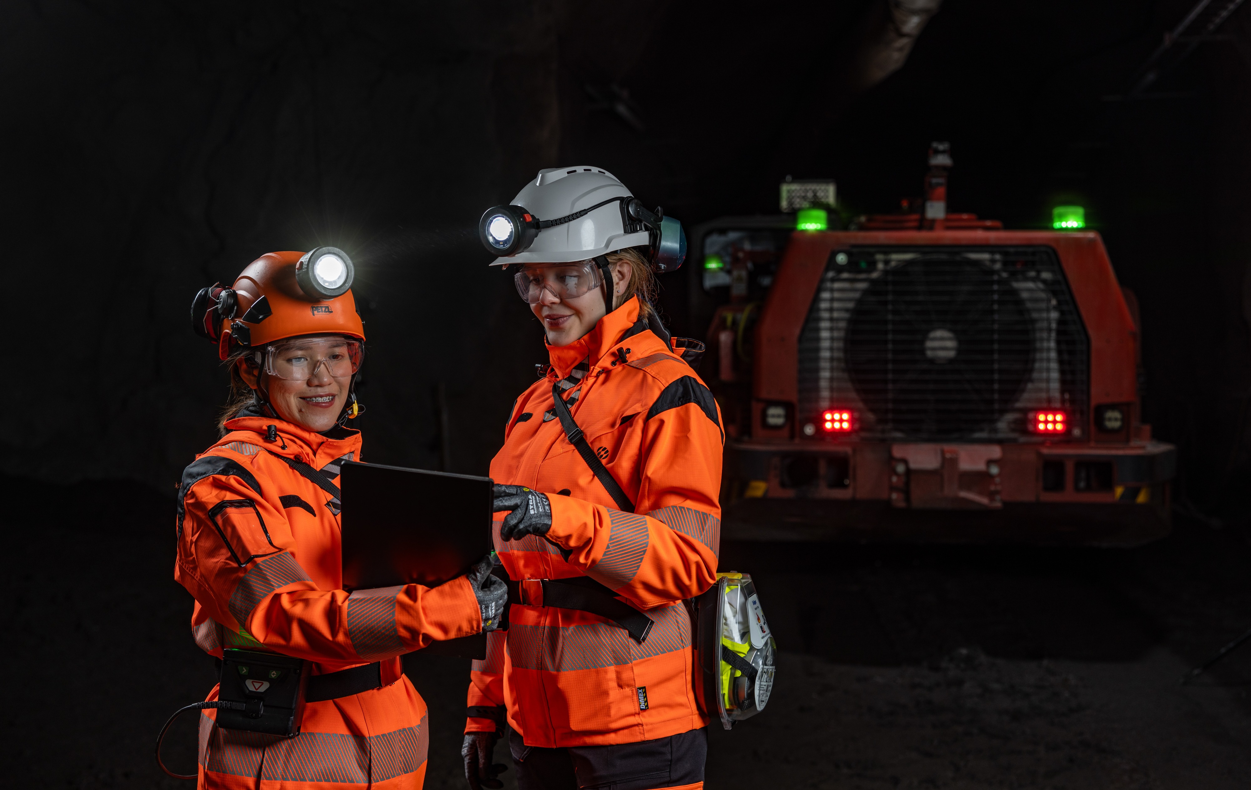 Two female mine operators are discussing in the mine passage