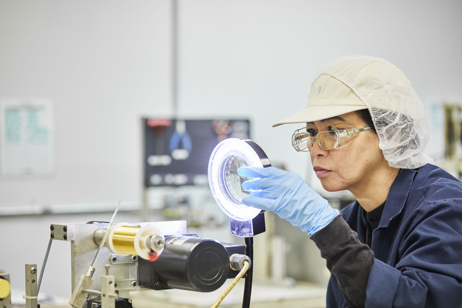 Laboratory assistent in protective clothing examines a sample